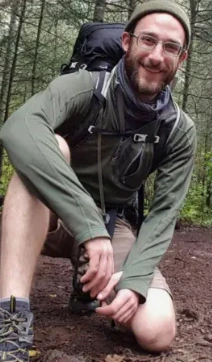 Alex Pretti, a 37-year-old ICU nurse, in scrubs standing solemnly with a candlelight vigil and Minneapolis skyline in the background, protesters holding signs saying 'Justice for Alex', police and DHS agents nearby.